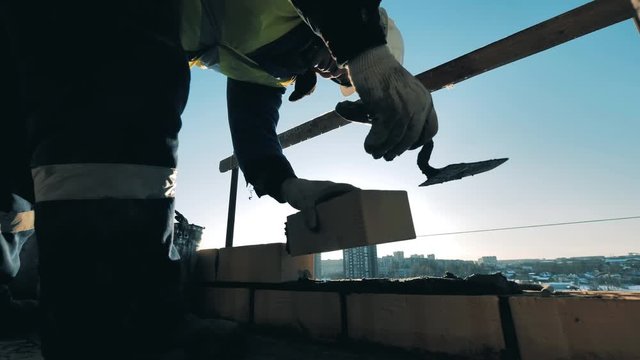 Construction worker at a construction site. Bricklaying is being carried out by a male constructor