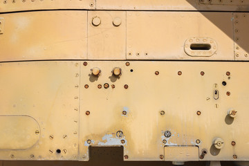 Details of the fuselage of an old aircraft. Old camouflage surface with exfoliated paint and rivets on a military aircraft.
