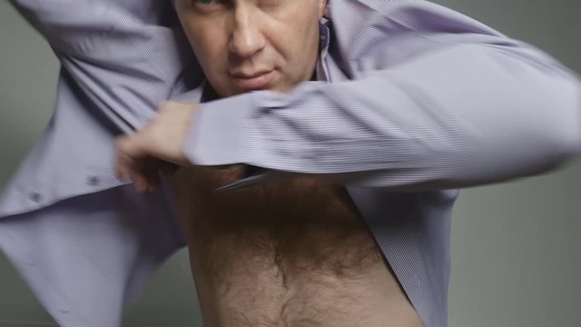 a young, handsome man with chest hair puts on a shirt and buttons it up. He is clean-shaven and has a dimple in his chin. 4K