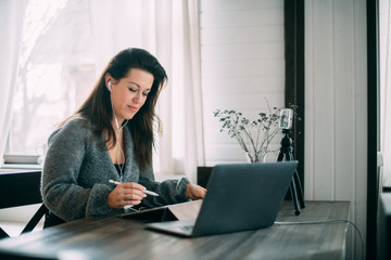 A woman works, conducts live broadcasts from home on the Internet