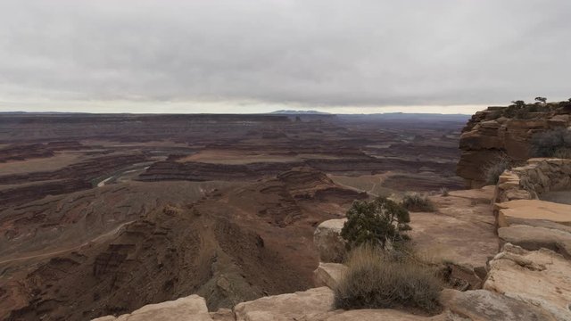 A wide timelapse looking out across Canyonlands National Park from Dead Horse Point as a thick layer of cloud flows overhead.