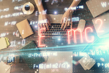Double exposure of woman hands working on computer and formula hologram drawing. Top View. Science concept.