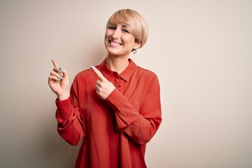 Young beautiful business blonde woman with short hair standing over isolated background smiling and...
