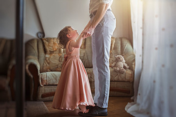 First daughter dance with dad. Little girl dancing on daddy's legs. Relations between dad and daughter.