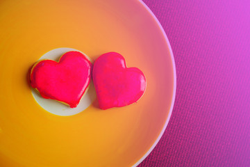 Heart shaped cookies that are coated in red sugar for a warm Valentine's day food or gift.