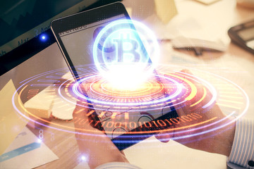 Double exposure of man's hands holding and using a phone and crypto currency blockchain theme drawing.