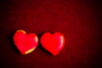 Heart shaped cookies that are coated in red sugar for a warm Valentine's day food or gift.
