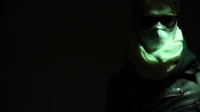 Man anti virus mask and glasses comes into the green light from shadow.