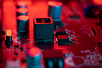 Close-up of the component side of a printed circuit board. Macro with bokeh. Red lighting, with...