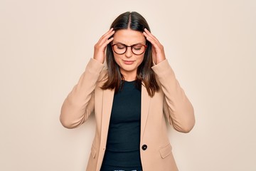 Young beautiful brunette businesswoman wearing jacket and glasses over white background with hand on head for pain in head because stress. Suffering migraine.