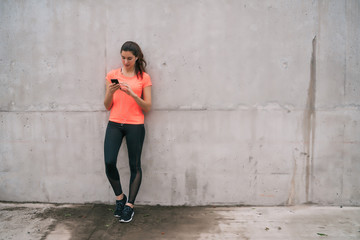 Fototapeta premium Athletic woman using her phone.