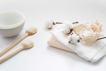 Fototapeta na wymiar Flor de algodón, tela y cucharas de madera sobre mesa blanca