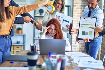 Group of business workers working together. Partners stressing one of them at the office