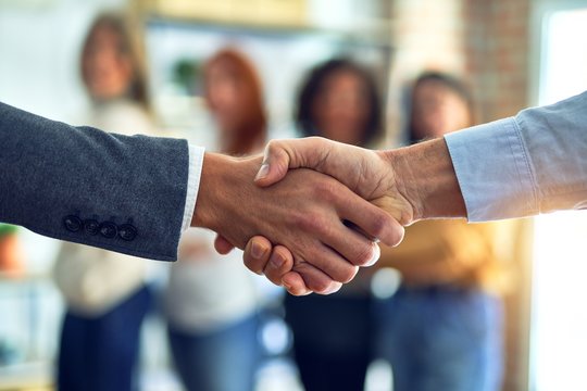 Group of business workers standing together shaking hands at the office