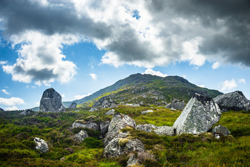 Fototapeta na wymiar Rocks speckle green hillside in Scottish Highlands