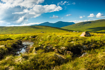 Water flows in bogs between rolling green hills