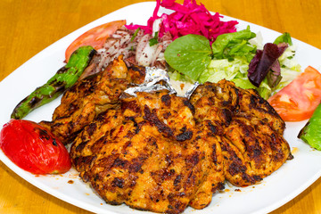 Turkish cuisine. Chicken chop on bone (pirzola) with vegetables