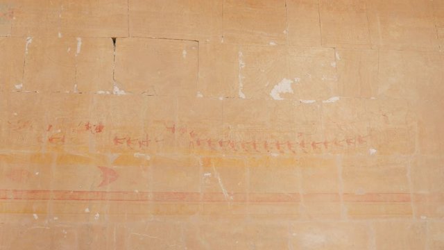 Red-Yellow Images of Pharaohs are on the Inside Wall of the Building. The Brown Paint That Was on the Wall is Beginning to Fall Off a Little.