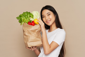 young woman holding a bag full of groceries