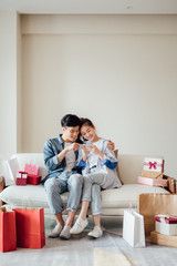 Young Asian couple at home using a smartphone
