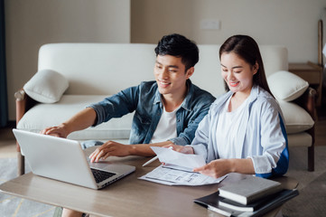 Young Asian couple at home using computer