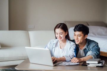 Young Asian couple at home using computer