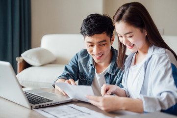 Young Asian couple at home using computer