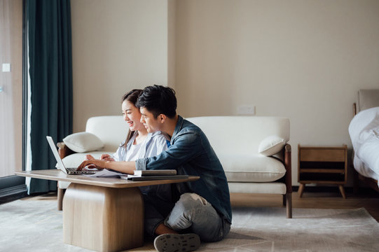 Young Asian couple at home using computer