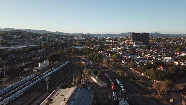 4K aerial Windhoek capital main railway station depot sheds, workshops and railway lines with trains parked area at bright sunrise drone video in Khomas Region, central Namibia