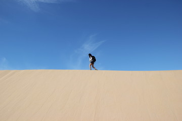 Fototapeta na wymiar girl walking on the sand