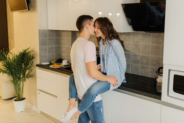 Smiling young couple in the kitchen having a great time together. Relationship concept.