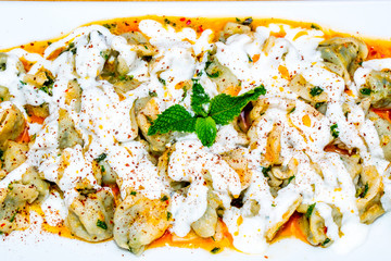 Turkish Manti with red pepper, tomato sauce, yogurt and mint (dumplings)