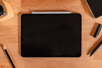 Flat Lay of tablet pro and stylus on a wooden desk with an empty space for copy or vectors