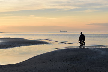 pedalear en bicicleta en la playa al atardecer en el Río de la Plata, Berisso, Argentina