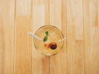 top view,Iced plum juice in clear glass with decorative plum on top Placed on a wooden table,  closeup cocktail or mocktail with tropical fruit, The perfect summer drink.