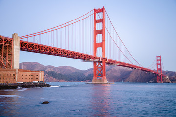 Fototapeta na wymiar The famous Golden Gate Bridge in San Francisco, California. Beautiful sunlight hitting the bridge as cars drive over it. 