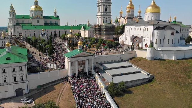 Top view of the Pochaev Lavra at the moment when a lot of people enter it. Orthodox procession in the monastery.