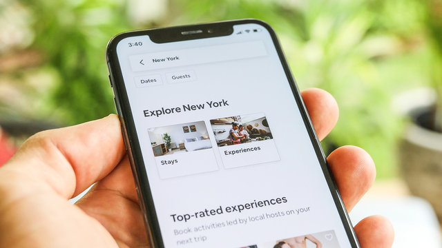 NEW YORK CITY, NY  December 1, 2019: Woman trying to book home apartment room in New York City using Airbnb app