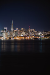 Fototapeta na wymiar Nighttime view of San Francisco city. Calm and peaceful conditions in the bay as the city light illuminate the water. 