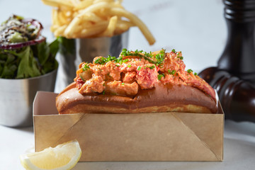 lobster roll on slate surface and burger