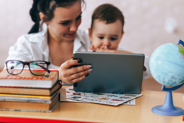 Happy mother and son watch educational videos, mother and son talk on video calls, the teacher deals with the child, educational games, quarantine