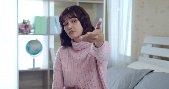 Upset young asian woman and waved hand to expel