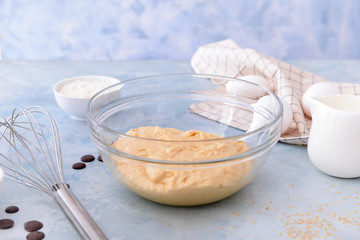 Bowl with sweet dough on color background