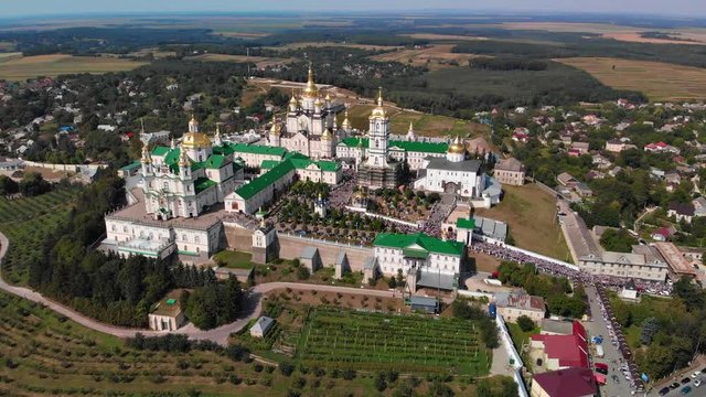 Top view of the Pochaev Lavra at the moment when a lot of people enter it. Orthodox procession in the monastery.