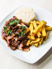 Traditional Peruvian dish Lomo Saltado (Beef saltado). Lomo saltado is a stir fry that typically combines marinated strips of sirloin with onions, tomatoes, french fries and typically served with rice