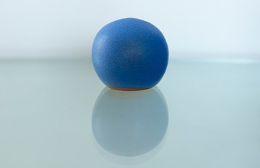 Cobalt blue ceramic ball against a white background. Pottery salt cellar made in Crete Greece.