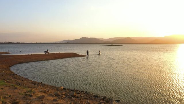 February 29th, 2020 - Perlis, Malaysia : 4k Aerial View of a man fishing at Timah Tasoh Lake side During Beautiful Sunset with scenic Mountain view. Establishing, Drone Rising Forward Shot