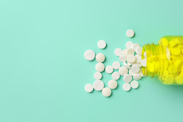 Bottle with pills on color background