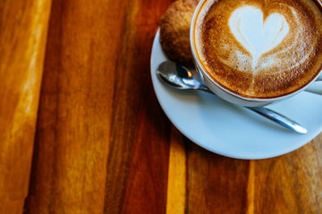 Close up cup of cappuccino in a white cup on a saucer with cookies. Top view copy place