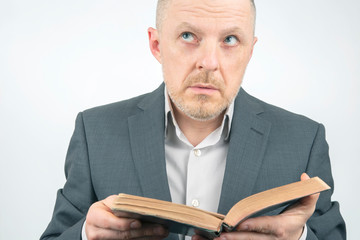 man in a business suit is reading the bible.